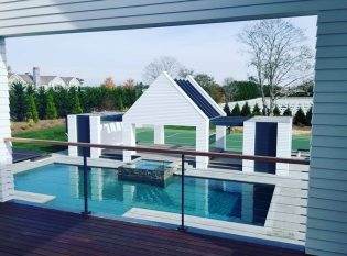 Master bedroom deck with stainless steel cable railing system overlooking backyard pool area.