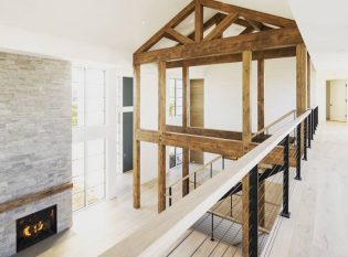 Rustic modern farm house with timber frame and black cable railing system on balcony and stairs