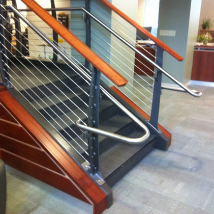 Railing extension on handrail of college lobby staircase