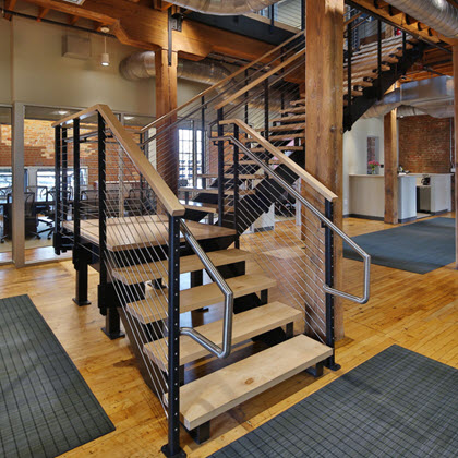 A college staircase with extended steel handrail on cable railing