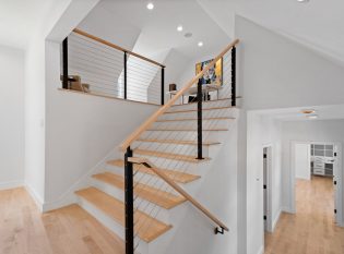 Cable railing system on staircase to loft with handrail