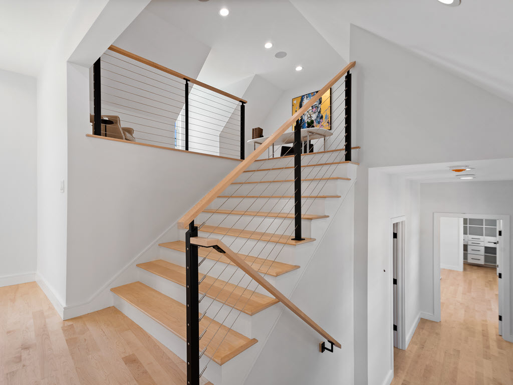 Cable railing system on staircase to loft with handrail