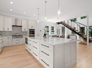Expansive kitchen open to the living space with center entrance floating stairs.