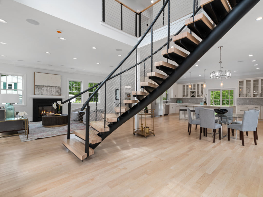 Entrance floating staircase with steel stringer and cable railing system on curved floating stairs