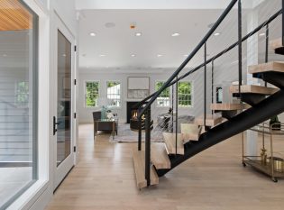 Open living with curved floating staircase in the main entrance