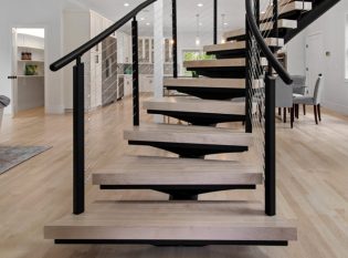 Center entry home with curved floating stairs and cable railings