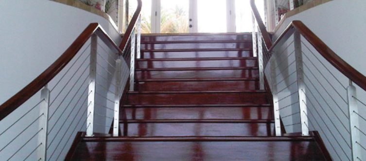 Stainless steel railing posts on mahogany stairs and top rail