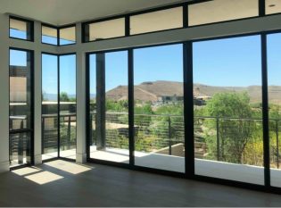 Window wall with mountain view and deck railing