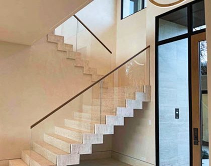 Travertine stair with glass railing in grande entry with glass door entrance