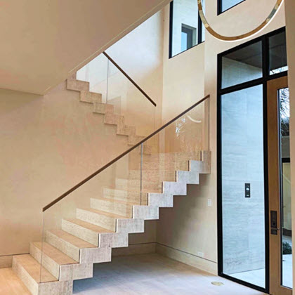Travertine stair with glass railing in grande entry with glass door entrance