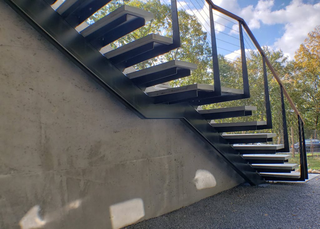Exterior biased cantilever staircase with stone steps and steel supports