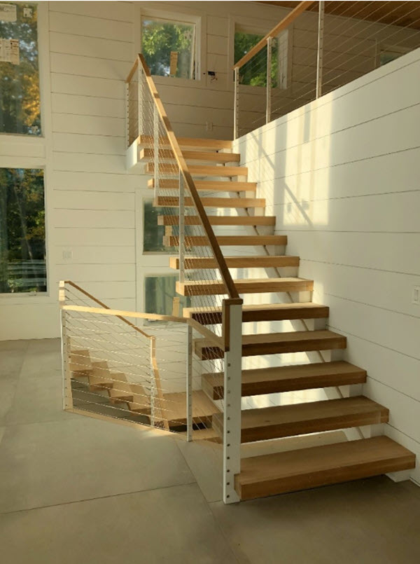 Exposed stringer on one end of cantilever steps with cable railing