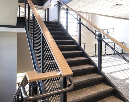 Industrial style cable railing system on stairs with ADA handrails