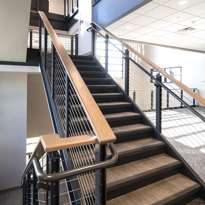 Industrial style cable railing system on stairs with ADA handrails