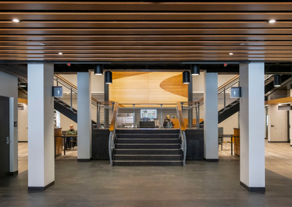 Bifurcated staircase with wood steps and curved cable railings