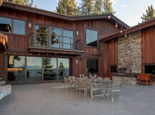 Balcony with curved cable railing overlooking outdoor dining patio.