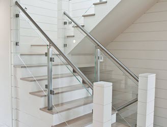 Glass railing on stairs with stainless steel handrail, posts, and clamps