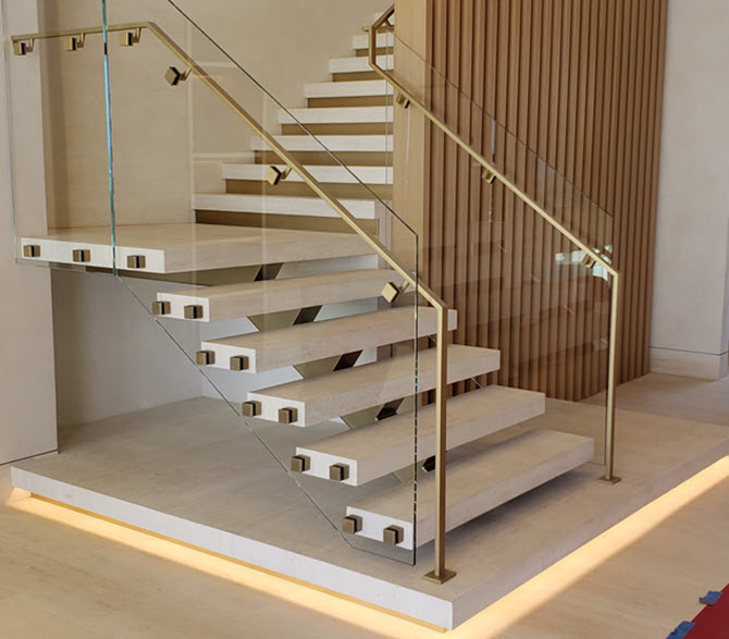 Interior floating stairs with travertine treads, brass hand rails and glass standoffs 