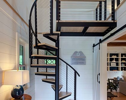 Spiral staircase in entrance of telegraph house with shiplap walls