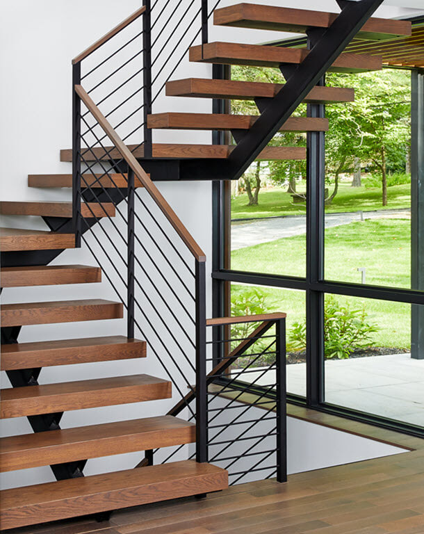 Floating mono stringer stairs with horizontal pencil railing.