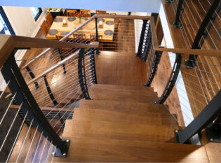 Curved cable railing system on center staircaase