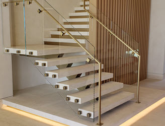 Floating stair with travertine treads, glass and brass railings.  