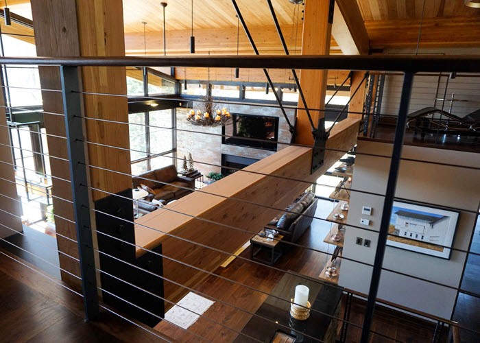 Slim post cable railing on balcony overlooking great room with large timber construction