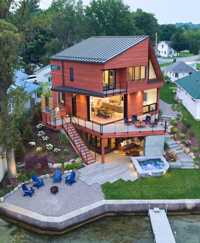 Exterior of Lake house with large patio and deck featuring cable railings on deck and stairs