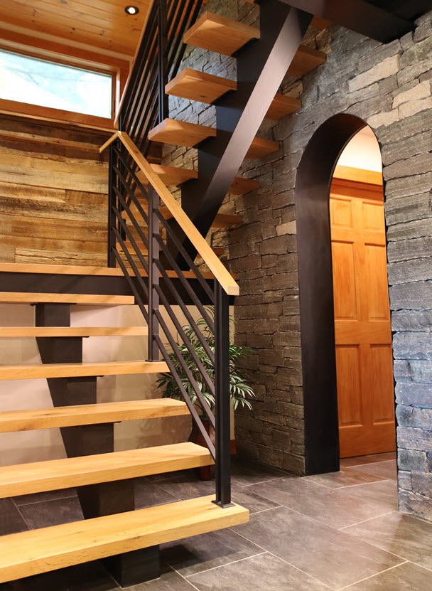 Modern Metal Railing with horizontal flat bars and unique double bar posts on floating stairs. The treads and top rail are antique oak in a rustic setting.