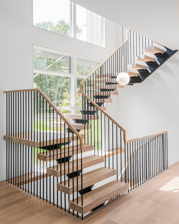 Modern Metal Railing with vertical spindles on a multi level floating staircase. In a modern setting.