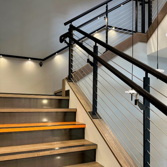 Open stiarcase with cable railings and LED lighting in the handrails