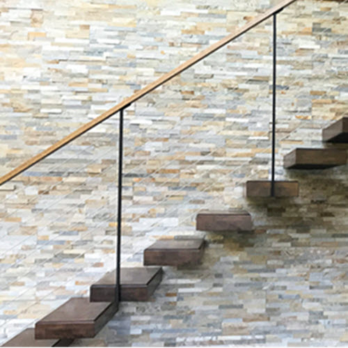 Cantilevered stair with stringer hidden in stone wall, wood treads and a cable railing