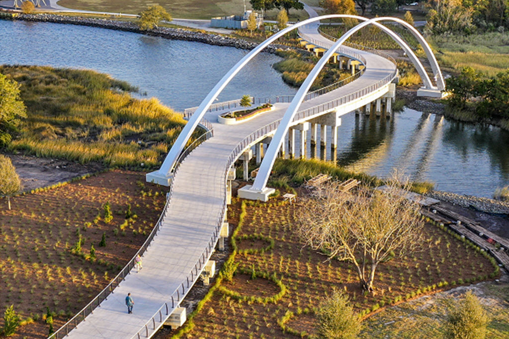 Curved Cable railing on pedestrian bridge with massive arches and water vuews.