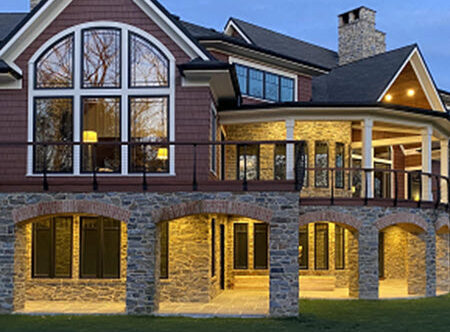 Expansive deck with stone arch supports and curved black cable railing system