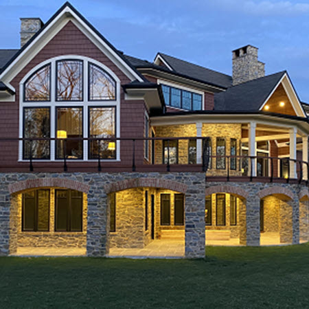 Expansive deck with stone arch supports and curved black cable railing system