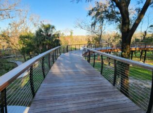 Curved cable railings on raised bridge boardwalk