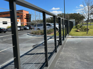 Expansive cable fence with driveway gate