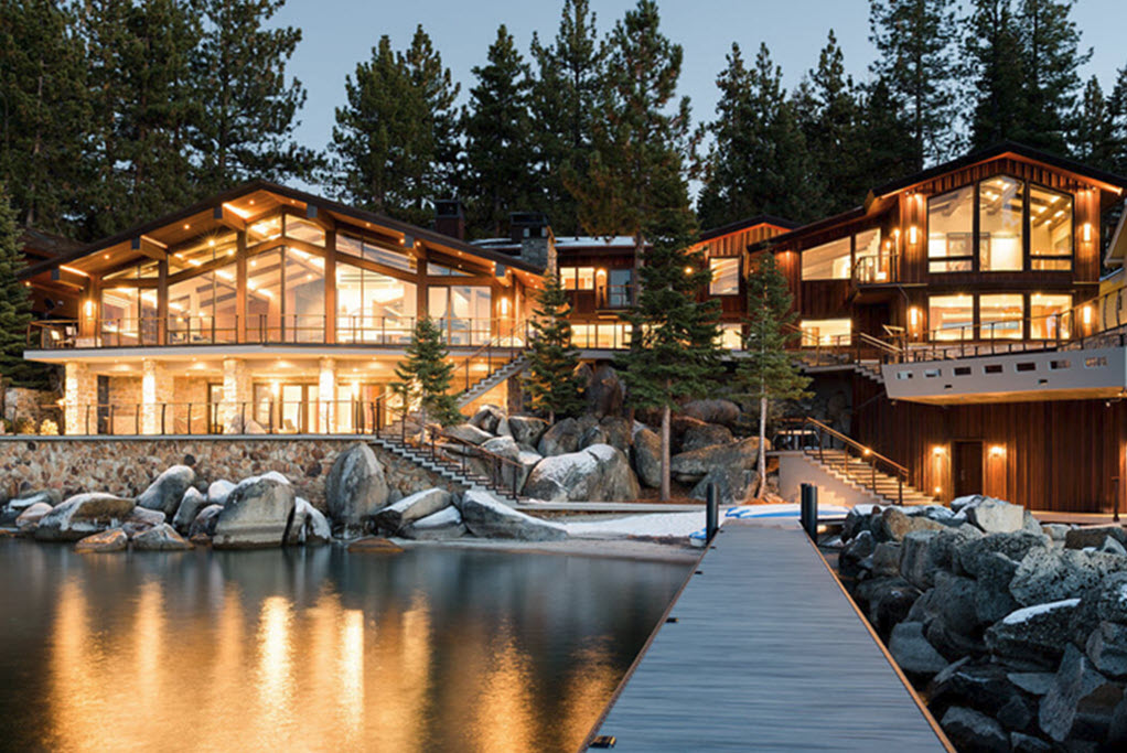 View of Large Lakefront home on Lake Tahoe with night lighting and Keuka Curved railing system wrapping decks, stairs and pool