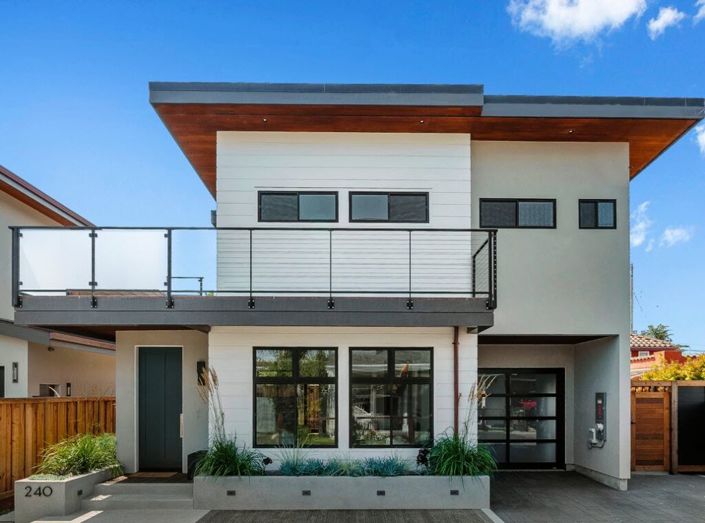 Modern architecture of a home with an upper level baclony that features our Ithaca style cable and glass railing system.