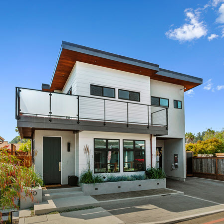 Modern California home exterior with upper level balcoy that showcases a frosted glass and cable railing.
