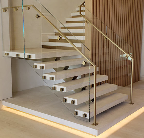 Glass railing with brass handrail on floating stair with traverting treads