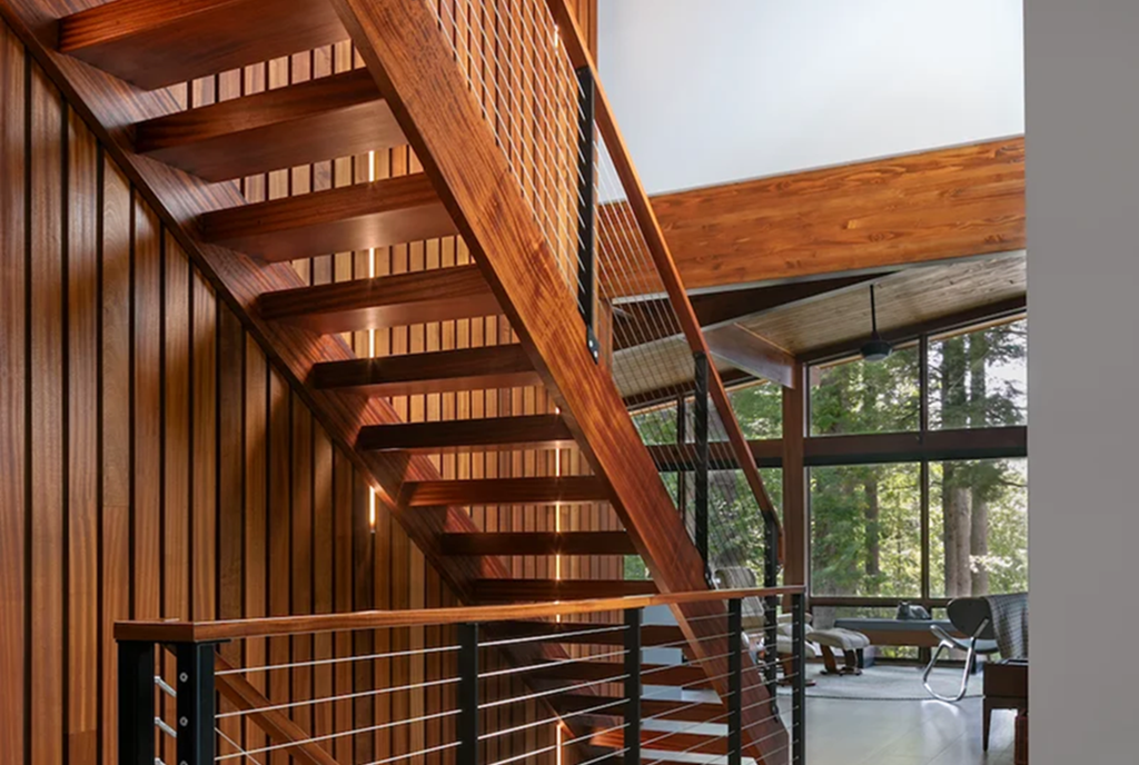 Wood stairs and handrails blend beautifully with the matching wood slat wall that adds ambiance with vertical LED lighting in the wall.