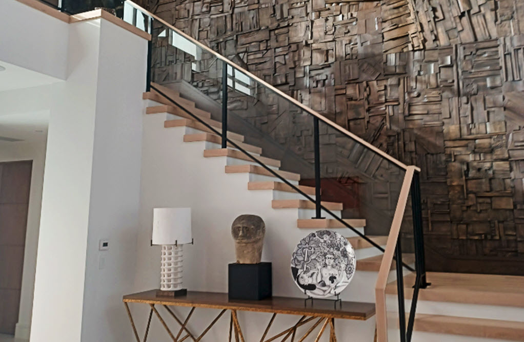 Sculptural wood walls with a unique rustic aesthetic creates a contrast to the refined framed glass railing.