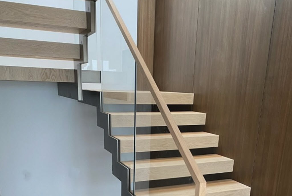 Zig Zag stringer stairs with white oak treads and dark wood feature wall paneling create a unique contrasting color interior design style.