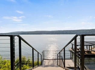 Ithaca cable railing system with black posts and top rail wrap the exterior floating stairs