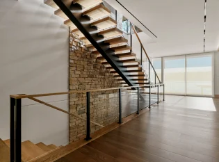 Interior floating mono stringer staircase with glass railings 
