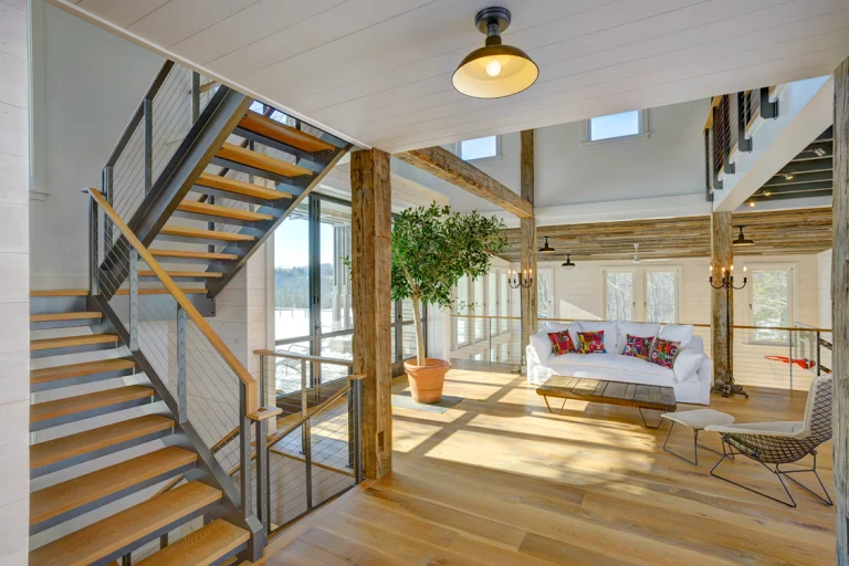 Ithaca style cable railing  posts and industrial style stair stringers in open activity barn. The stair stringers are made of c-channel.