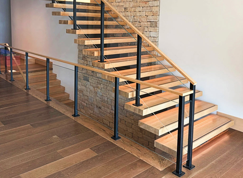 Glass Railing recessed in post floating stair Keuka Studios Modern floating stairs with glass railings. The glass is recessed into the vertical posts resulting in no visible glass hardware for a clean minimalist appearance. The treads are white oak wtih integrated LED lighting