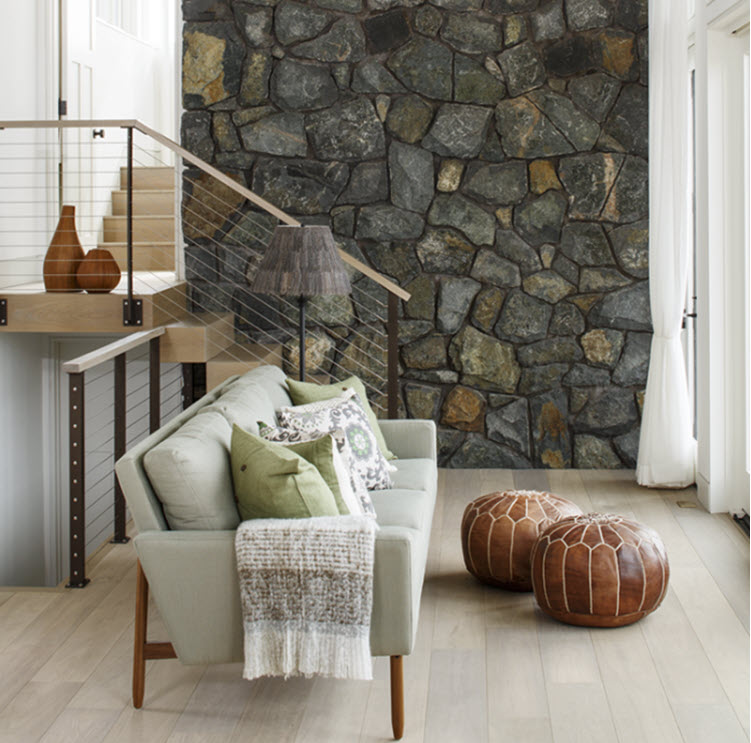 Interior stair with cable railing and stone wall.