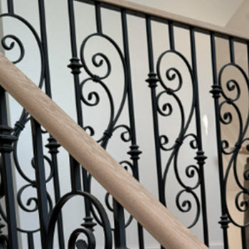 Ornate railing with metal scrolls and wood top rail.